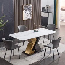 Charger l&#39;image dans la galerie, Modern rectangular white marble dining table with black and gold geometric base, surrounded by gray upholstered chairs in a stylish dining area with wood accent wall
