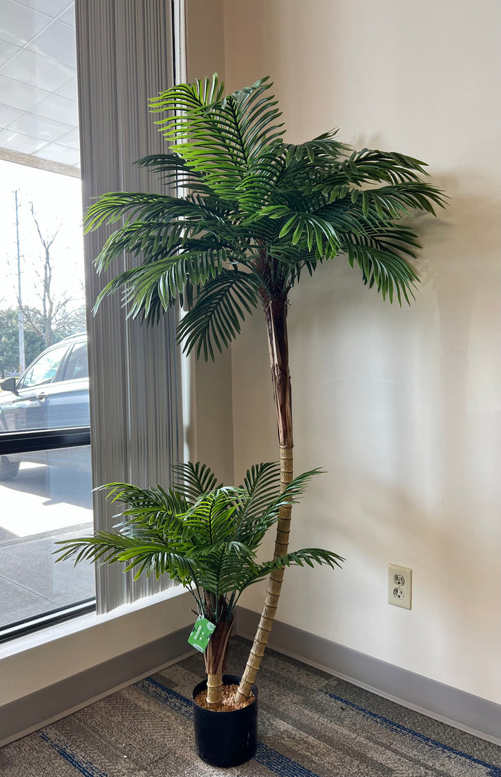 Artificial palm tree with detailed close-up of lush green fronds and a realistic trunk base, perfect for home or office decoration.
