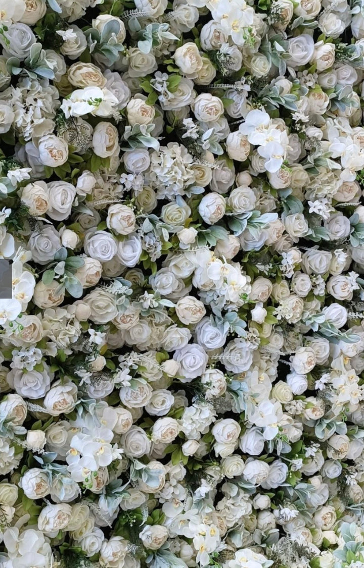 Close-up of a luxurious artificial floral backdrop featuring an arrangement of white roses, orchids, and lush green accents. Ideal for wedding ceremonies, corporate events, and photo backdrops. 
Is the backdrop customizable in size and flower selection? How realistic do the flowers look in person? Can it be used both indoors and outdoors?