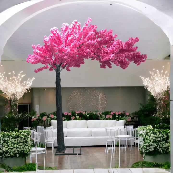 Elegant artificial cherry blossom tree with pink flowers, perfectly placed amidst a lavishly decorated wedding venue featuring pink floral arrangements and cascading fairy lights. Can this artificial tree be customized to match different event themes?