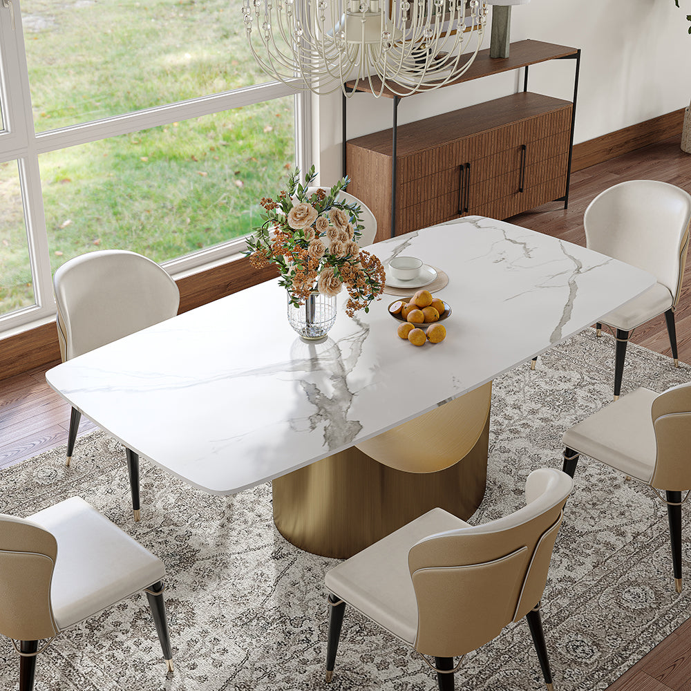 Elegant dining table with a white marble top and gold cylindrical base, perfectly accented with comfortable cream-colored chairs