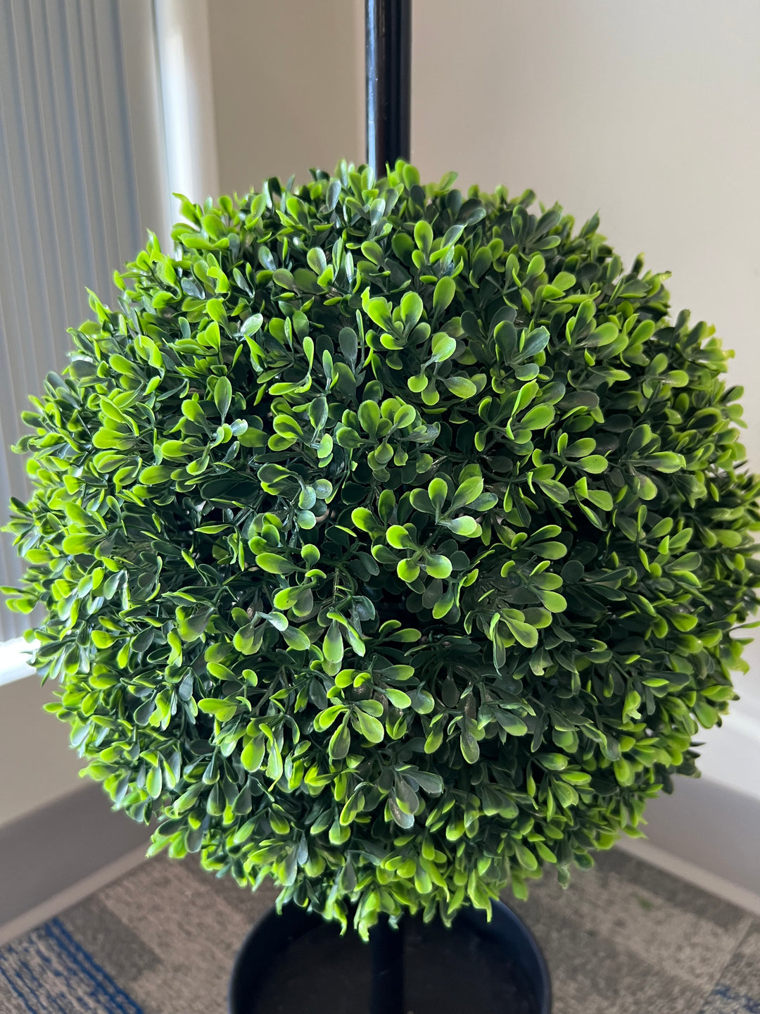 Close-up of a lush artificial topiary ball, featuring vibrant green foliage for an elegant and realistic look.