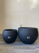 Charger l&#39;image dans la galerie, Two matte black planters of different sizes placed on a carpeted floor. The smaller planter is labeled #1, and the larger planter is labeled #2. Both planters have a round, minimalist design, perfect for modern indoor and outdoor spaces.
