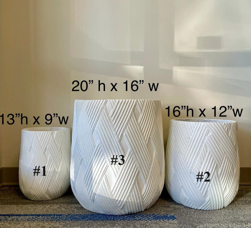 Three white textured planters of varying sizes arranged on a carpeted floor. The planters feature a stylish geometric pattern. Ideal for both indoor and outdoor use, these planters add a modern and chic touch to any space.