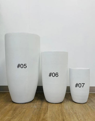 Three white planters of different sizes labeled as #05, #06, and #07, placed on a wooden floor against a plain background. How do I select the right size planter for indoor plants?