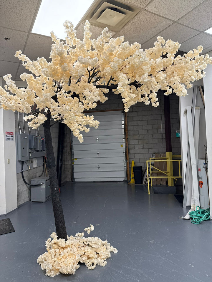 10ft off-white cherry blossom artificial arch tree in a warehouse setting.