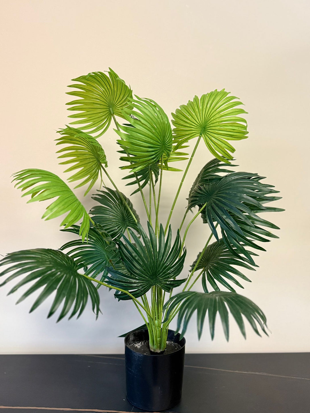 Artificial fan palm desk plant with realistic textured leaves in black nursery pot.