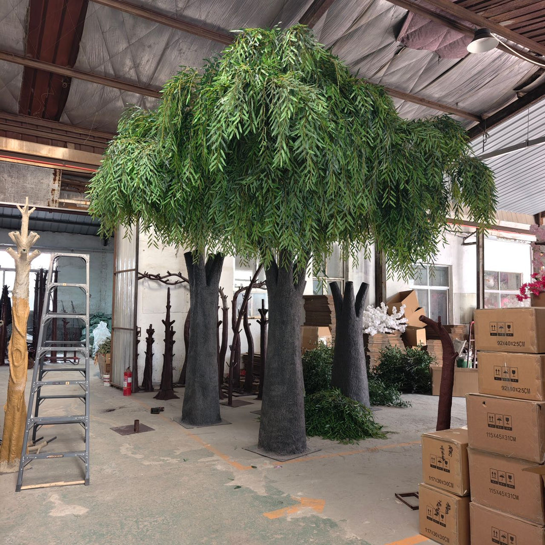 Large artificial willow tree in a warehouse setting.