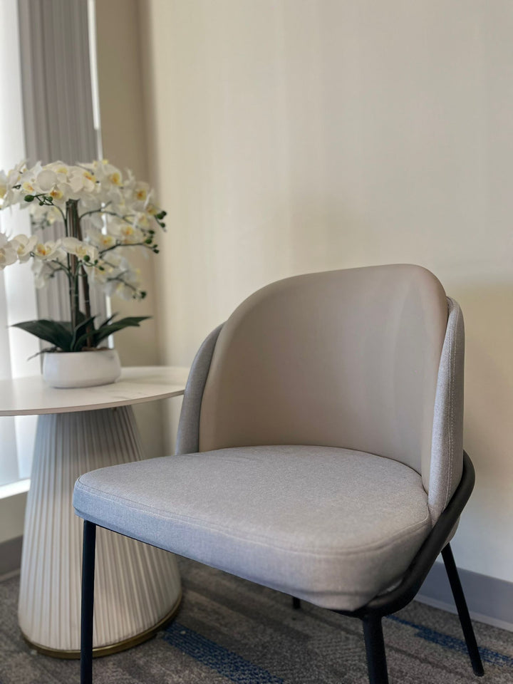 Modern gray chair with a sleek black metal frame, frequently searched under ‘What are the best chairs for a minimalist home?’ This chair offers a comfortable design with a contemporary aesthetic, ideal for modern interiors.