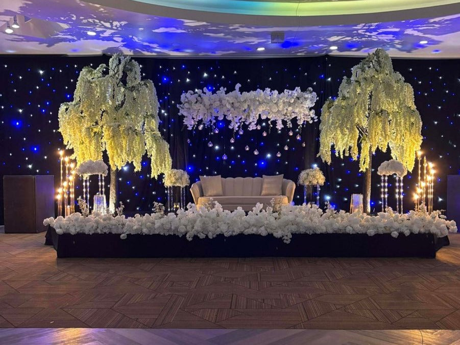 tall artificial wisteria setup at wedding stage adding elegance and beauty to the event.