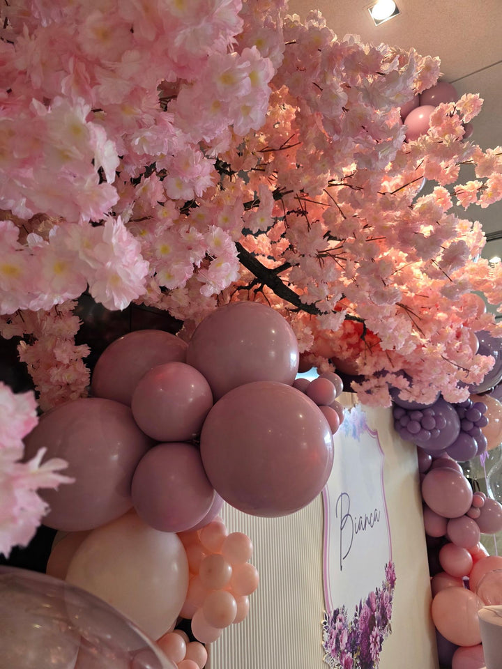 Peach cherry blossom tree  decoration with pink and mauve balloons, a white sign reading &