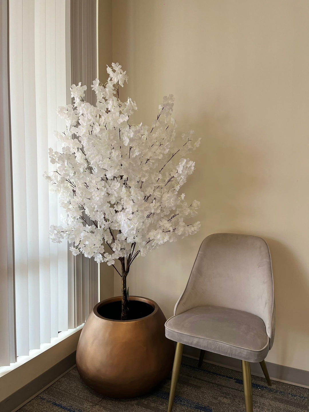 Artificial cherry blossom tree with internally wired branches shaped outward for a balanced canopy, photographed in a clean studio environment.