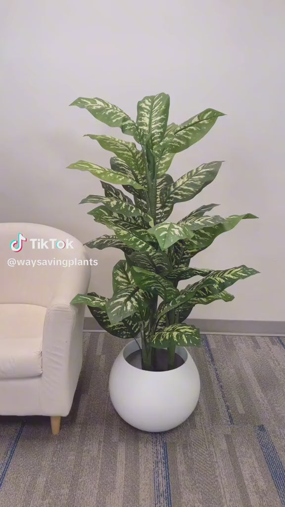 Large artificial plant with lush green leaves in a modern white planter, perfect for enhancing indoor spaces such as offices or living rooms.