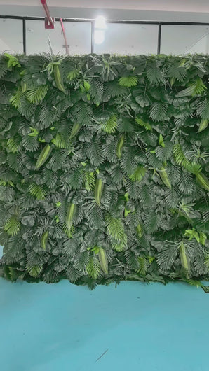 Artificial tropical green leaf backdrop featuring a variety of realistic foliage. Perfect for event decoration, photo booths, and indoor or outdoor settings. How durable is this artificial greenery wall for extended outdoor use? Can the individual leaves or sections be rearranged for custom designs?