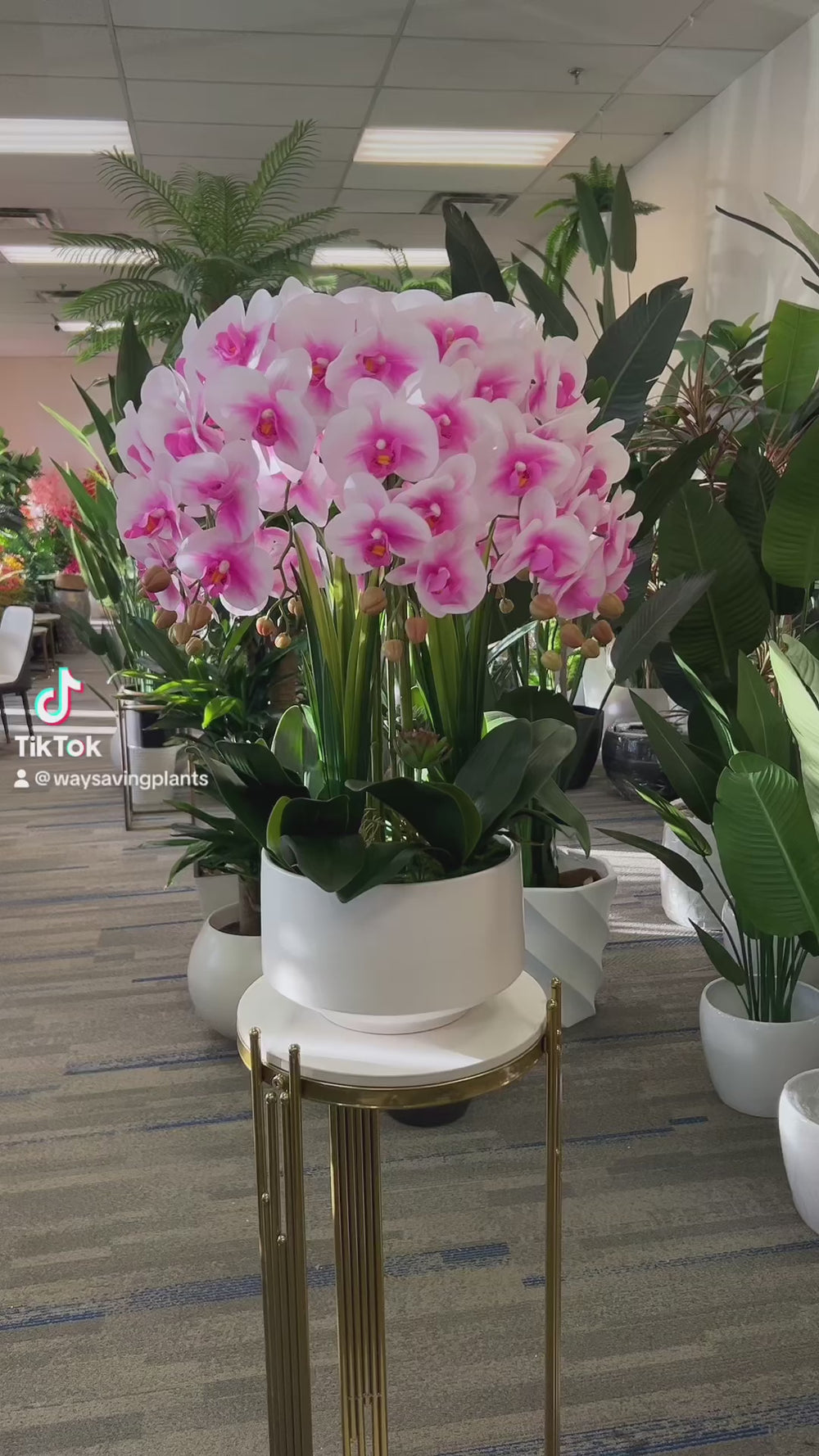 A beautiful artificial orchid arrangement in soft pink and white hues, set in a white ceramic pot with realistic green leaves and yellow buds. How do I maintain the freshness and appearance of artificial orchid flowers?