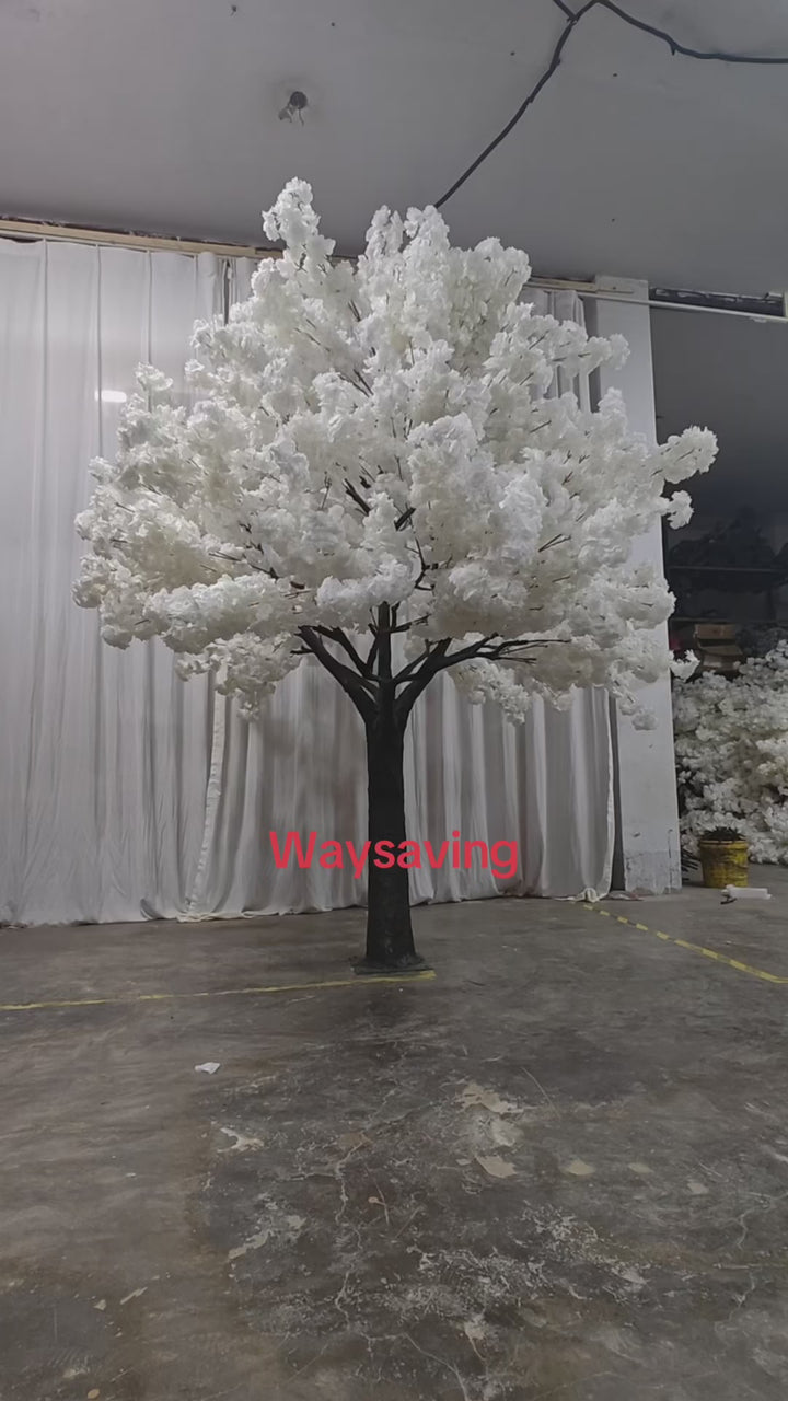 A tall artificial white blossom tree with a sturdy base, displayed against a plain white backdrop. Suitable for indoor event decor and photo backdrops. How durable are the materials used for these artificial trees?