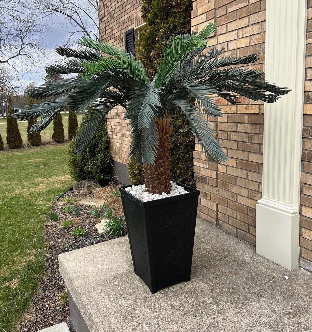 Outdoor artificial palm tree in a modern black planter, perfect for adding a tropical touch to patios, porches, or garden spaces.
