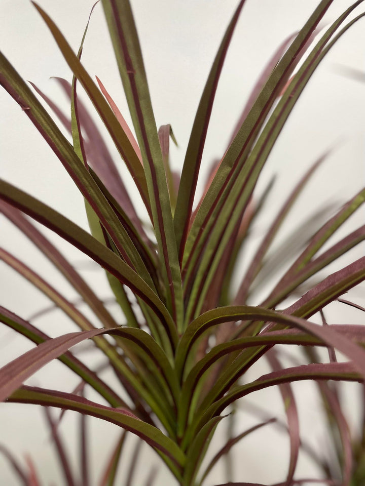 Close-up of artificial Dracaena plant leaves with long, pointed green foliage, ideal for indoor decoration and adding a modern touch to home or office spaces.