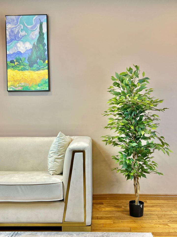 An elegant indoor setting featuring a sleek white couch and a vibrant green potted plant, complemented by a colorful landscape painting on the wall.