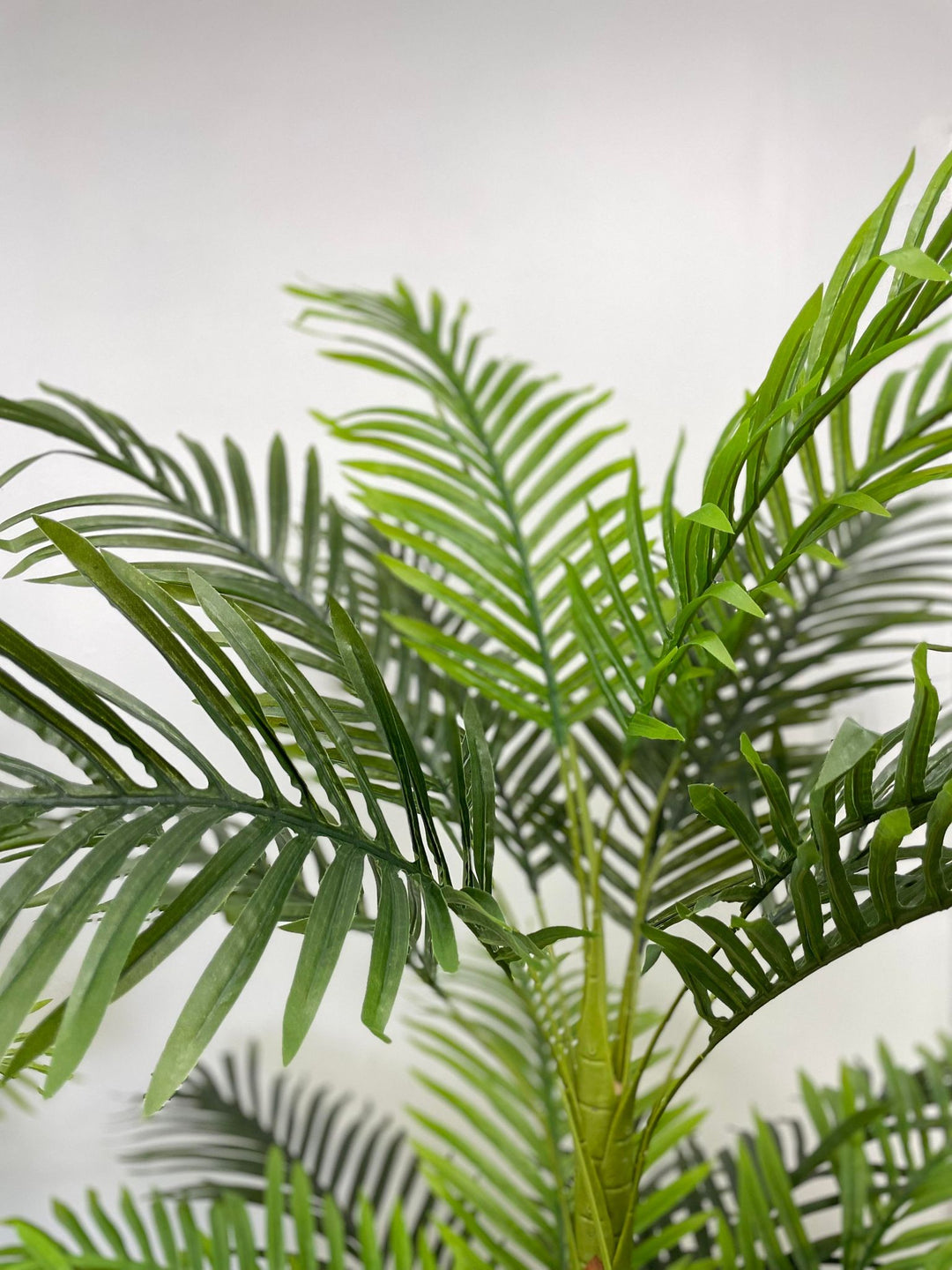 Close-up view of lifelike artificial palm fronds, ideal for enhancing indoor and outdoor spaces with a natural, tropical ambiance