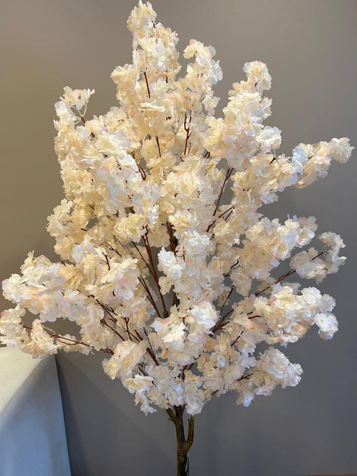 Close-up of an artificial cherry blossom tree showcasing its full bloom of soft, delicate flowers, ideal for enhancing interior decor with a touch of elegance.
