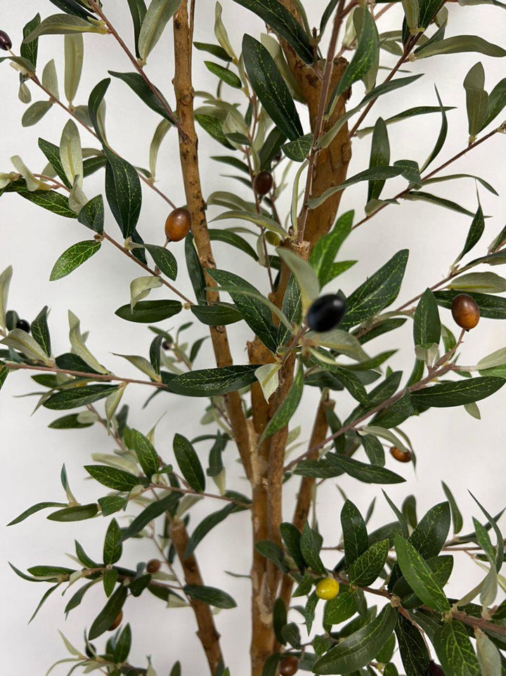 Close-up view of the artificial olive tree's leaves and small dark olives, showing the detailed texture and realistic design of the foliage against a neutral background.