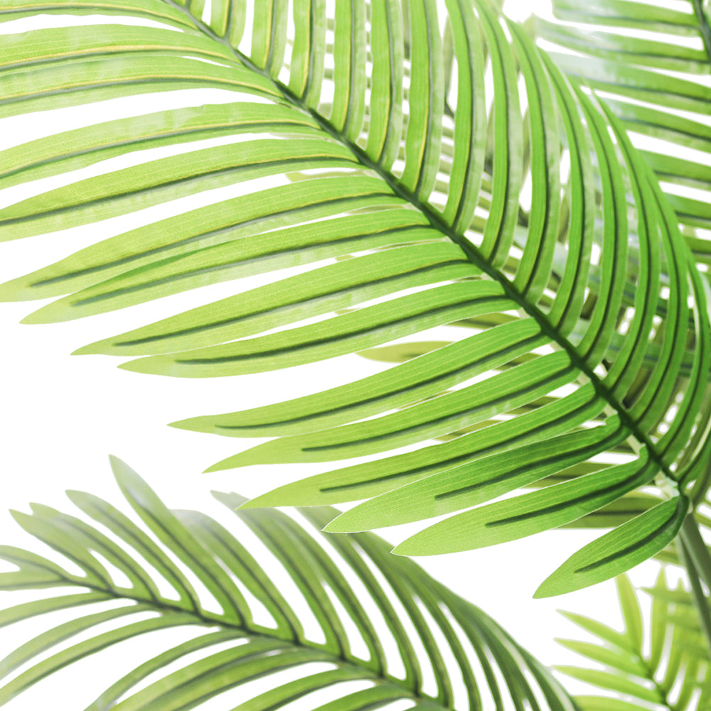 Close-up of vibrant green artificial palm leaves, showcasing their detailed texture and lush tropical aesthetic, perfect for enhancing indoor decor with a natural touch.