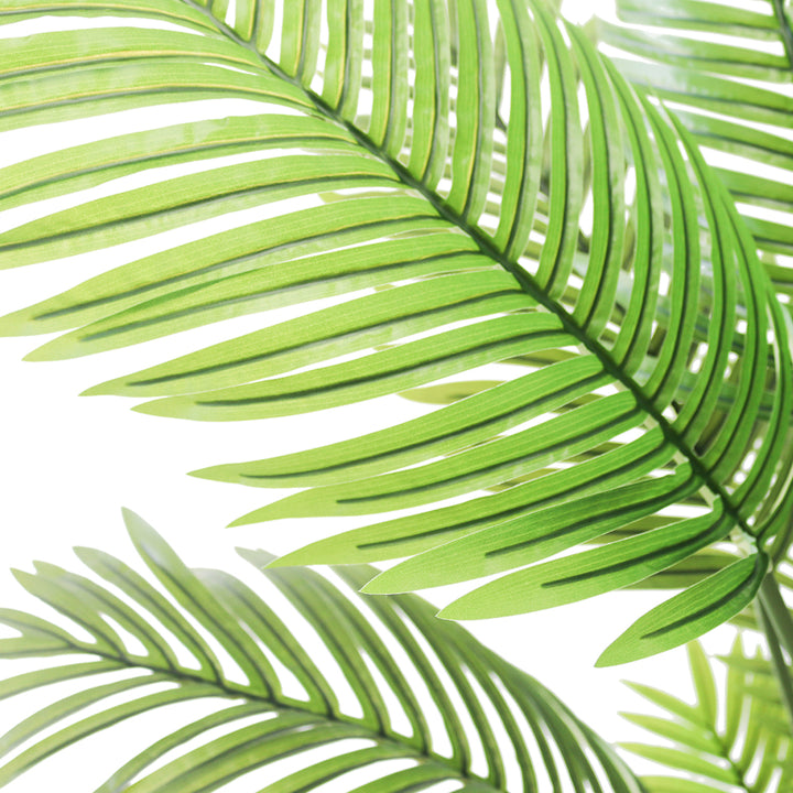 Close-up of vibrant green artificial palm leaves, showcasing their detailed texture and lush tropical aesthetic, perfect for enhancing indoor decor with a natural touch.