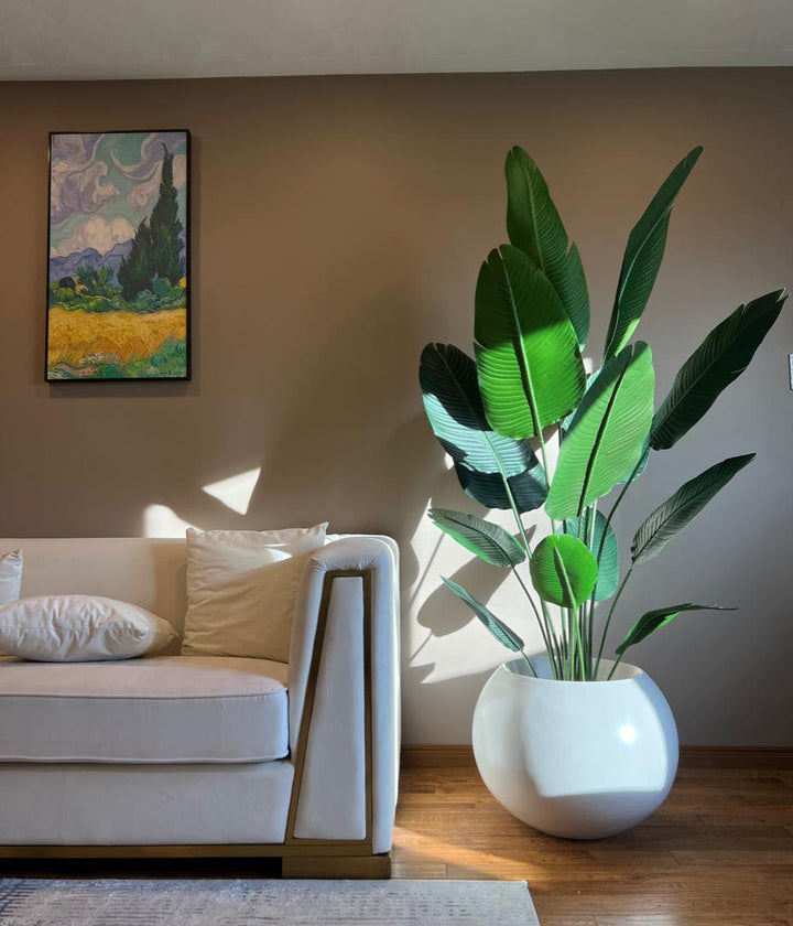 Lush 220cm faux Bird of Paradise plant styled in modern living room corner.
