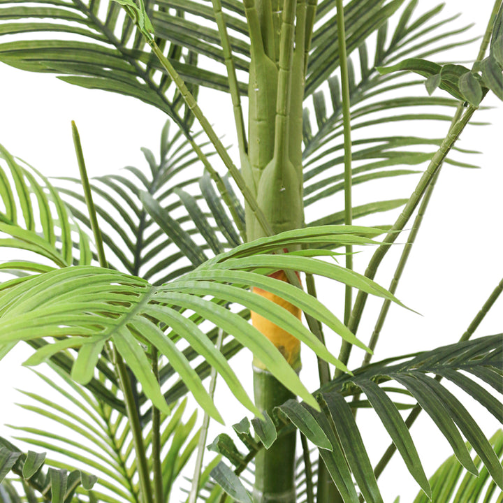 Close-up of artificial palm fronds, showcasing vibrant green leaves and realistic detailing, ideal for indoor decoration.