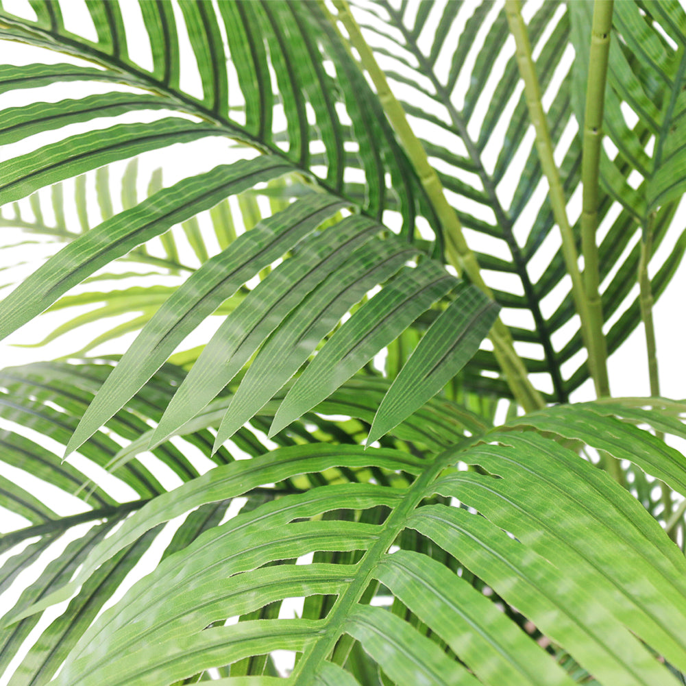 Close-up of artificial palm fronds, showcasing vibrant green leaves and realistic detailing, ideal for indoor decoration.