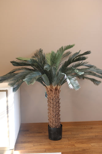 Artificial palm tree with realistic textured trunk and lush green fronds, perfect for enhancing any indoor space with tropical flair.