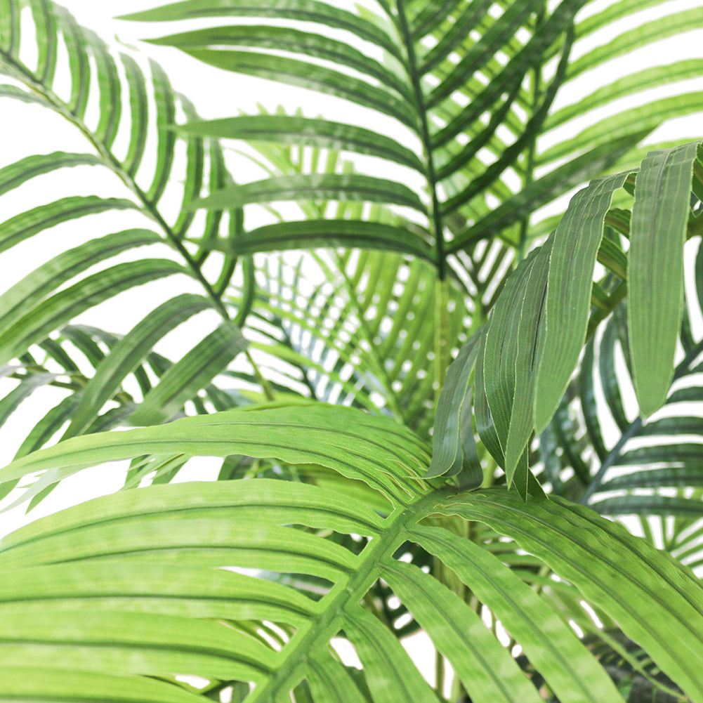 Close-up of vibrant green artificial palm leaves, showcasing their detailed texture and lush tropical aesthetic, perfect for enhancing indoor decor with a natural touch.
