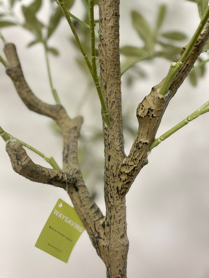Close-up of the detailed trunk and branches of an artificial olive tree with a textured, lifelike appearance. A green tag with the brand name "Waysaving" is attached to one of the branches. The tree features realistic bark textures and connected branches, making it a convincing decorative piece for indoor settings.