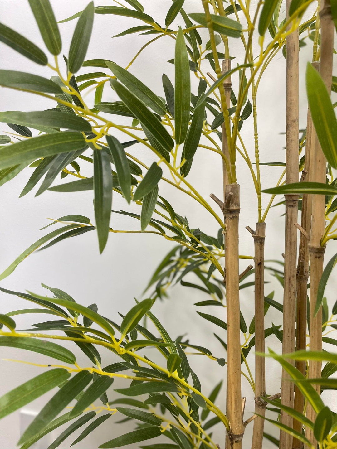 Close-up of real bamboo sticks used as trunks in artificial bamboo plant.