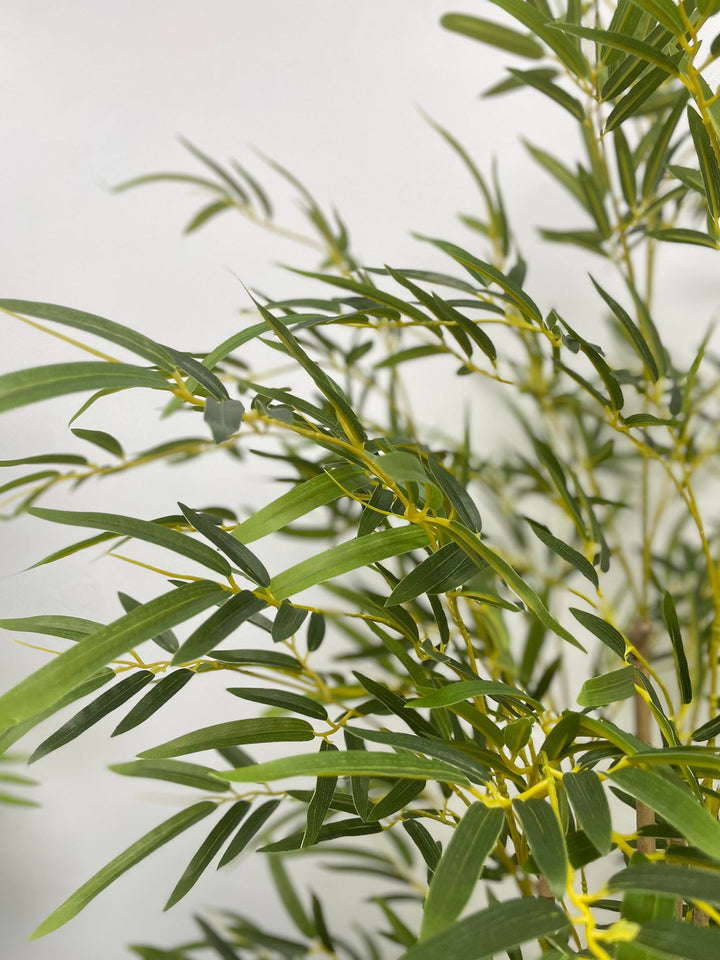 Detailed view of artificial bamboo leaves with narrow shape and natural green tone.