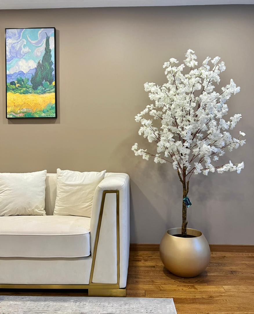 Elegant artificial white cherry blossom tree in a gold planter, adding a luxurious and serene touch to modern living spaces.