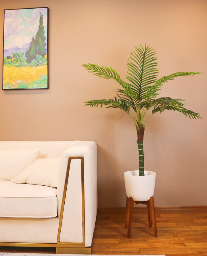Stylish artificial palm tree in a modern white planter, enhancing the aesthetic of a cozy living room.