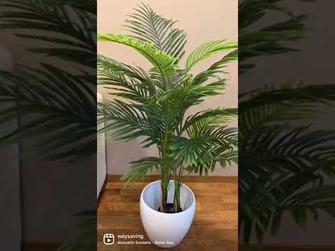 4.3ft artificial palm plant in a modern white ceramic pot, placed beside a luxurious white sofa with gold accents, creating a chic and contemporary living room decor.