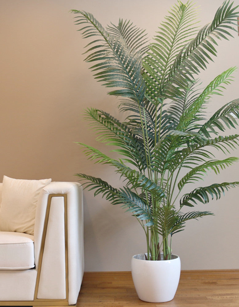 Artificial palm tree in a modern white pot, perfect for adding a tropical touch to indoor spaces with its lush green foliage.
